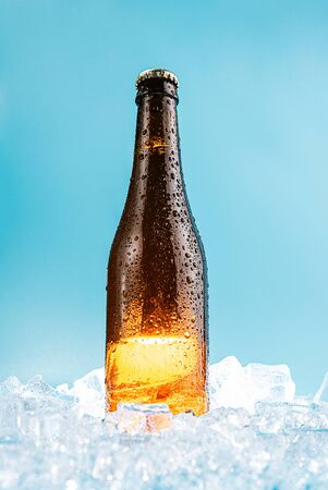 closed brown glass beer bottle on iceの写真素材
