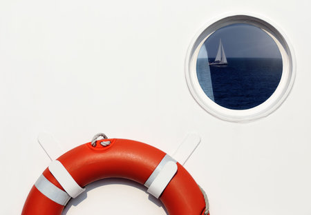 Life belt and porthole window with reflection on shipの写真素材