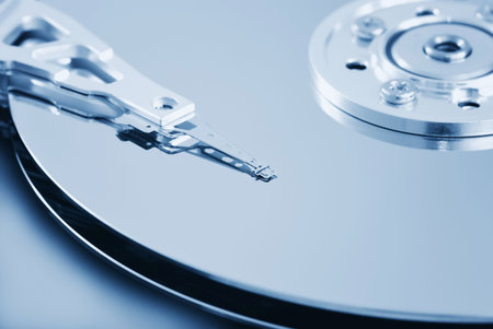 Open hard disk drive - shallow depth of field with focus on the head (toned in light blue)