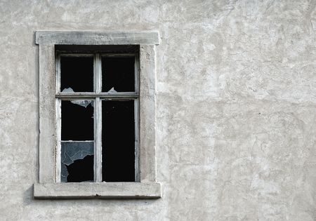 Broken glass window in old wall of abandoned houseの写真素材