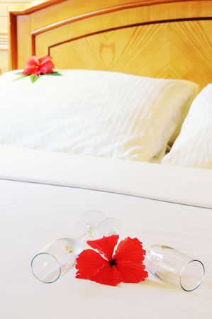 Two gasses with flower on bedsheet in hotel. Welcomes guests with champagne.の写真素材