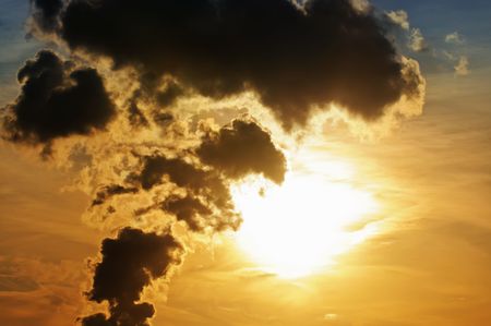Industrial sunset. Smokestacks backlit by the sun and dramatic sky.の写真素材