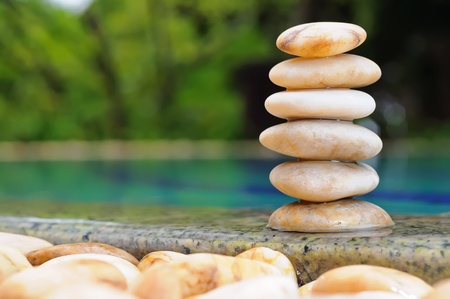 Pile of pebble stones against swimming pool の写真素材