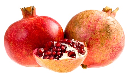 two whole  and half of broken pomegranates isolated on whiteの写真素材