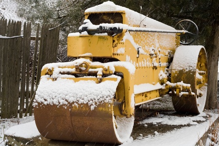 yellow road roller under snowの写真素材