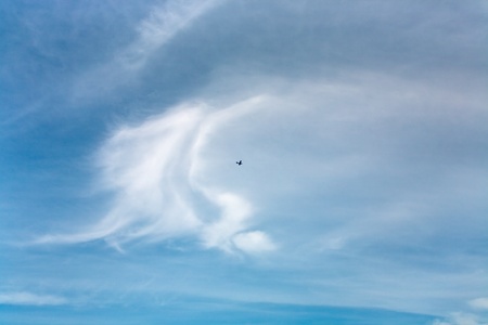 airplane in  blue sky with white cloudsの写真素材
