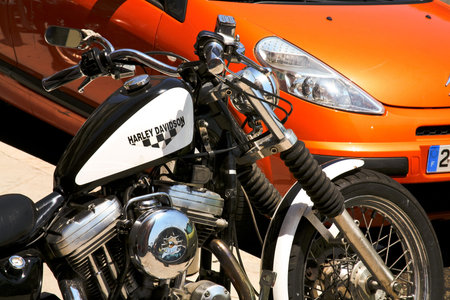 brutal Harley Davidson bike and  orange feminine Citroen on July 11, 2008 in Nice, France