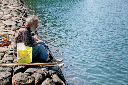 Old man fishes in summer day in Bretagne on July 4, 2010 in Ile de Brehat, Franceのeditorial素材