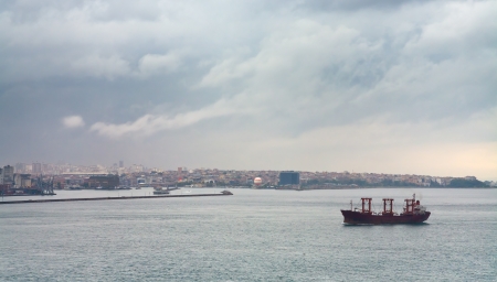 ship in Bosporus gulf and Istanbul view in overcast dayの写真素材