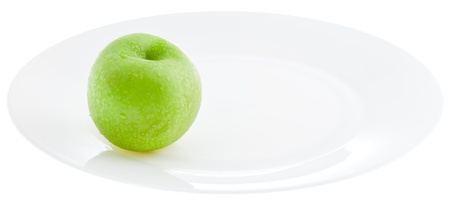 green apple on white plate isolated on white backgroundの写真素材