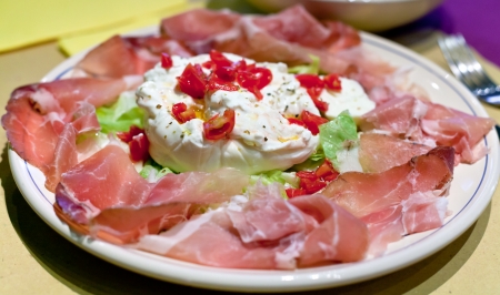 fresh italian burrata with parma prosciutto crudo on plateの写真素材