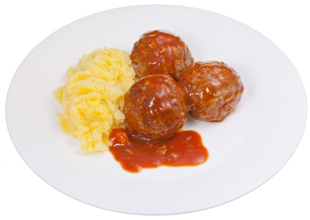 three roasted meatballs under meat sauce and mashed potato on plate isolated on white backgroundの写真素材