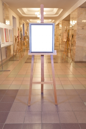 silver picture frame with white cut out canvas on easel in art gallery hallのeditorial素材