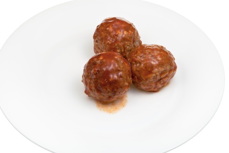 roasted meatballs under meat sauce on white plateの写真素材