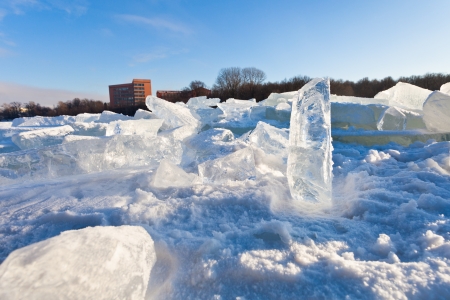 house and blocks of clear river ice in cold winter day in Moscow, Russiaの写真素材