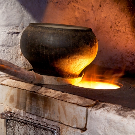 fire hearth of russian stove and old cast-iron pot with oven forkの写真素材