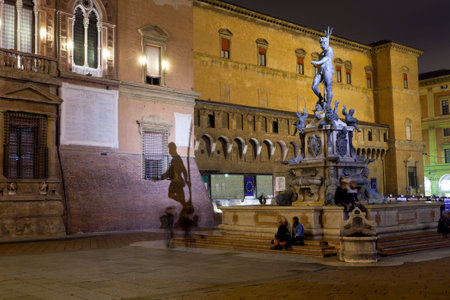 Fountain of Neptune on Piazza del Nettuno with shade on Sala Borsa in Bologna at night, Italyのeditorial素材