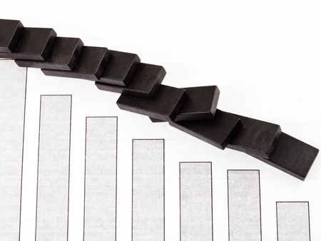 business concept - fallen domino and sales fall diagramの写真素材