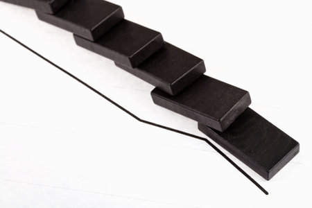 business concept - fallen domino and falling economy graph