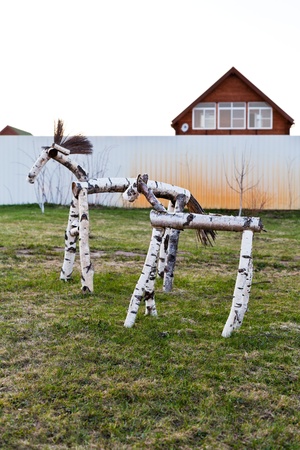 wooden horse figure on backyard of country village in spring eveningの写真素材
