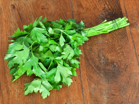 bunch of fresh green parsley on wooden tableの写真素材