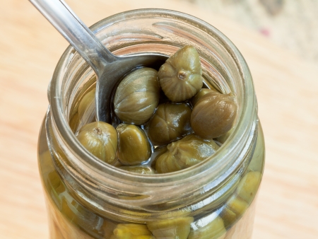 pickled capers in glass jar close upの写真素材