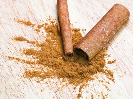 pinch of ground cinnamon and cinnamon bark close upの写真素材