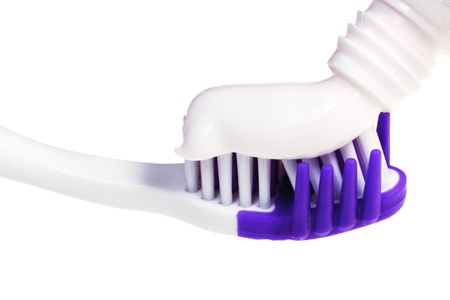 extruded tooth paste from tube on modern toothbrush close up isolated on white backgroundの写真素材