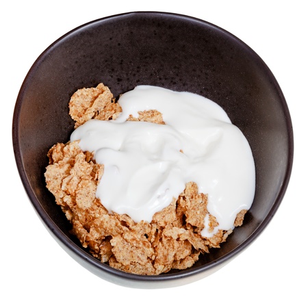 yoghurt into bowl of cereal isolated on white backgroundの写真素材