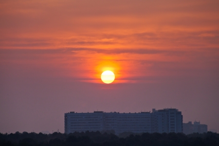 early morning red cloudscape over big house in cityの写真素材