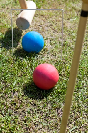 blue and red balls in game of croquet on green lawnの写真素材
