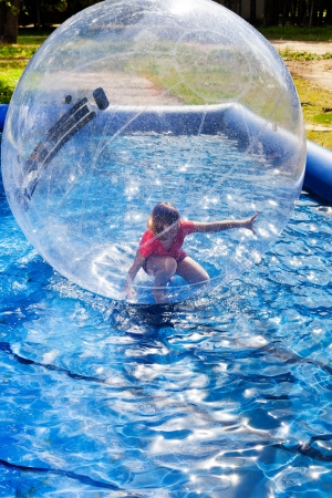 child in water ball in open swimming poolの写真素材
