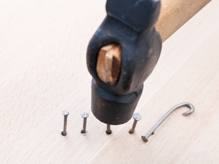 top view of hammer nails into wooden plank close upの写真素材
