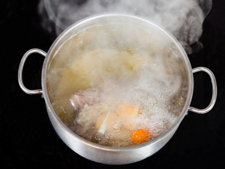 vapor over boiling of beef broth in pan on glass ceramic cookerの写真素材