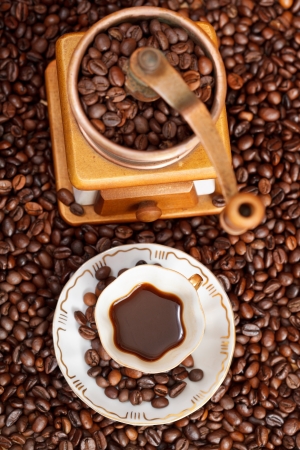 top view small cup of coffee and roasted coffee beans with retro copper manual millの写真素材
