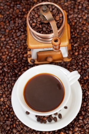 top view cup of coffee and roasted coffee beans with retro manual copper millの写真素材
