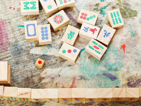 playing in mahjong game by wood tiles on shabby table closeupの写真素材