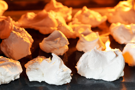 baking of sweet dessert meringue on oven trays close upの写真素材