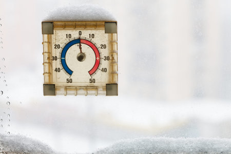 snow-covered home window thermometer in warm winter day