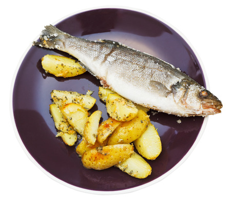 above view of sea bass fish baked in salt and fried potato slices on ceramic plate isolated on white の写真素材