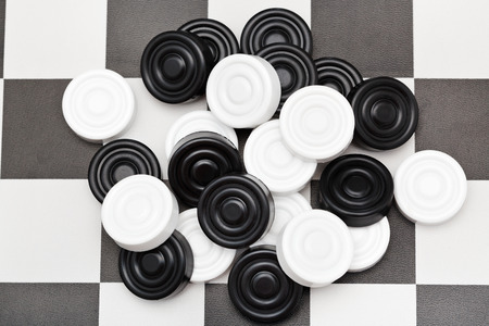 pile of checkers on black and white checkerboardの写真素材