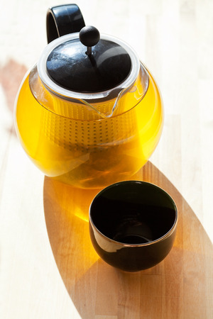 green tee in glass teapot and black drinking bowlの写真素材