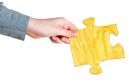 female hand with painted yellow puzzle piece isolated on white backgroundの写真素材