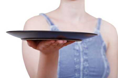 woman holds empty black plate on hand isolated on white backgroundの写真素材