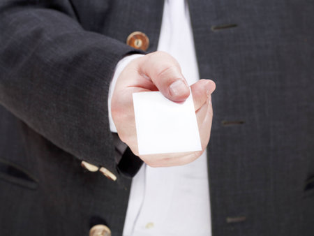 front view of blank white business card in male hand close upの写真素材