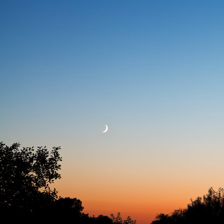 new moon in dark blue and red sky at late sunset in summerの写真素材