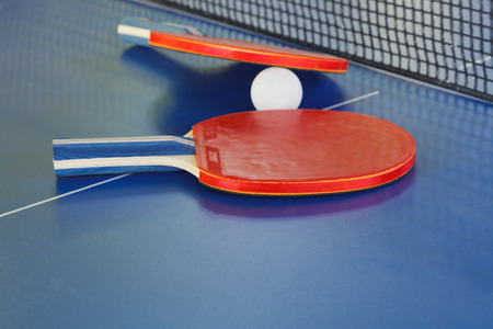 two paddle, tennis ball on blue ping pong table close upの写真素材