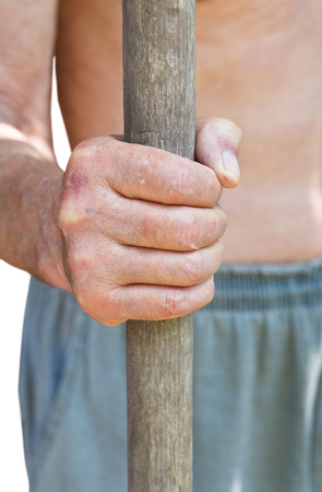 peasant holds old wooden handle of agricultural tool isolated on white backgroundの写真素材