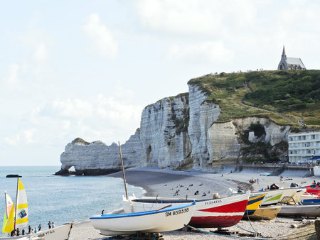 ETRETAT, FRANCE - AUGUST 4, 2014: tourists on resort beach near cliffs in Etretat town. The beach is best known for its cliffs, including three natural arches and the pointed "needle".のeditorial素材