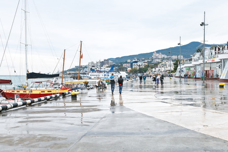 YALTA, RUSSIA - SEPTEMBER 27, 2014: tourists on Lenin embankment in Yalta city in rainy day. Yalta is resort city on the north coast of the Black Sea on the Crimean peninsula.のeditorial素材